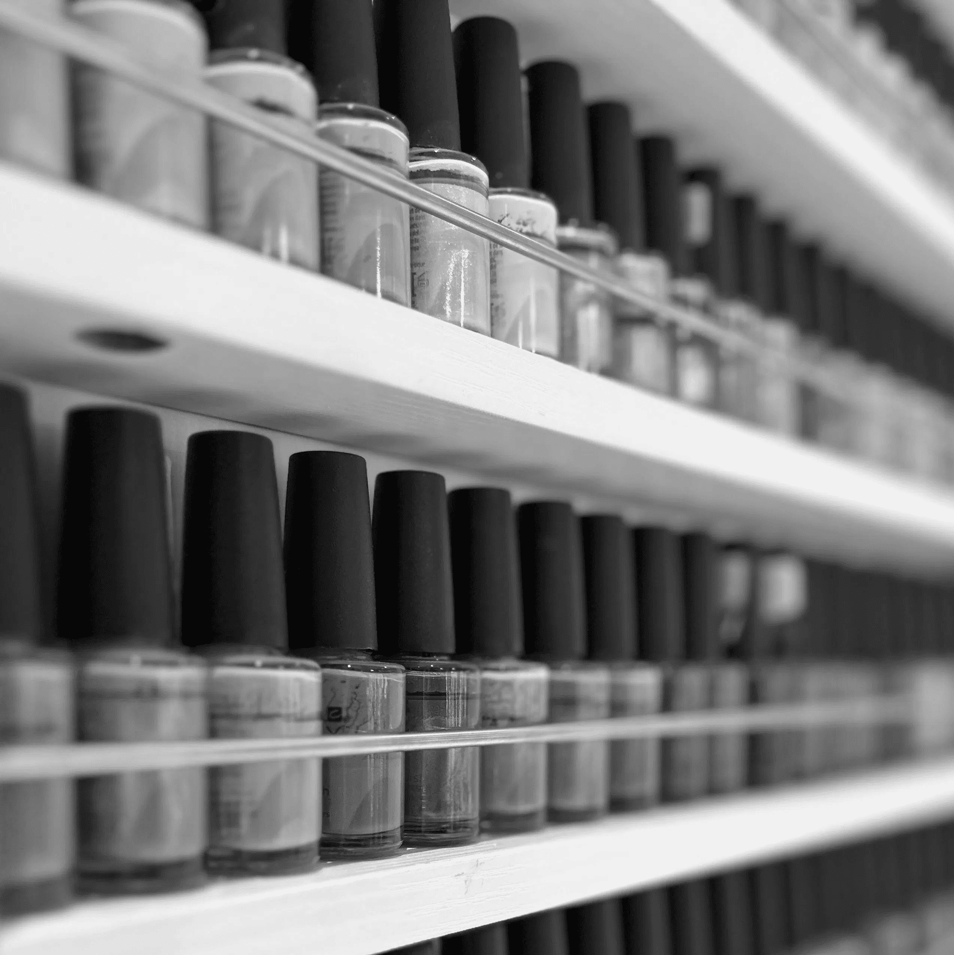 Nail polish bottles in various colors arranged on a shelf.